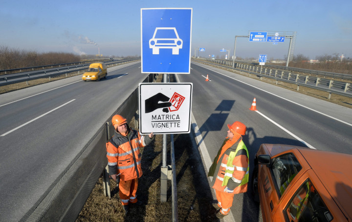 A Magyar Közút Nonprofit Zrt. munkatársai helyeznek ki egy a fizetős autópálya-szakaszt jelző táblát – Fotó: Máthé Zoltán / MTI