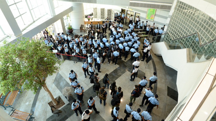 Rendőrök hatolnak be az Apple Daily szerkesztőségének épületébe 2021. június 17-én – Fotó: Apple Daily / AFP