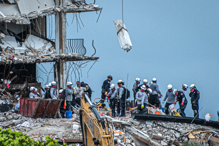 Mentőcsapatok kutatnak túlélők után az épület romjai között 2021. június 30-án – Fotó: Giorgio VIERA / AFP