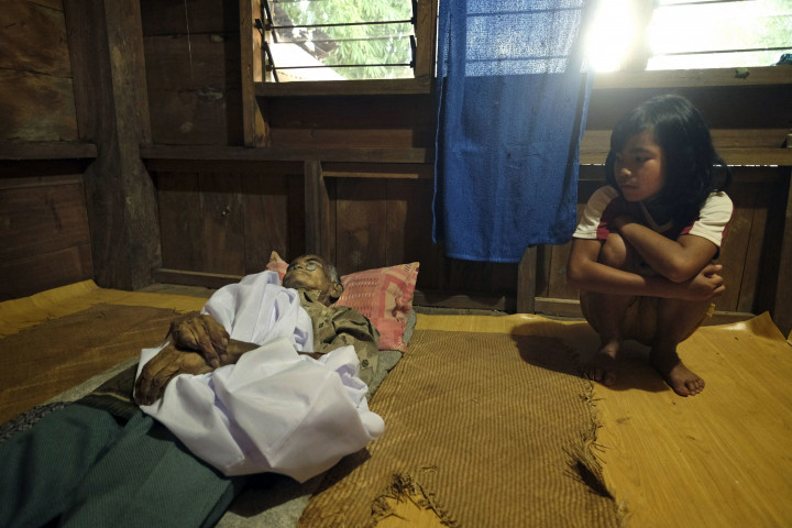 Egy családtag mumifikálódott holttestét készítik elő egy szertartáshoz a Celebesz-szigetek egyik településén – Fotó: Schroeder Alain / Hemis / AFP