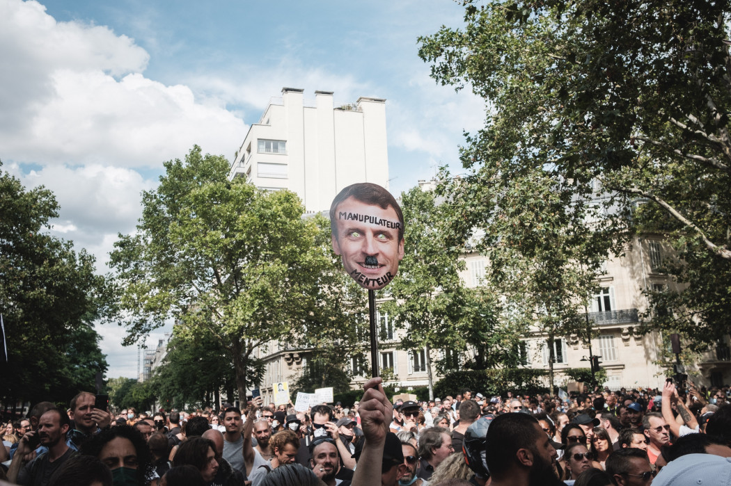 Hitler-bajszos Macront ábrázoló transzparens egy 2021. júliusi párizsi tiltakozáson – Fotó: Hans Lucas via AFP