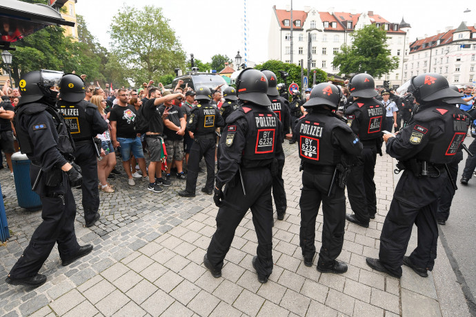 Rendőrök állnak az ünneplő magyar szurkolók mellett a Wiener Platzon, miközben a stadionba tartó buszokra várnak – Fotó: Tobias Hase / dpa / dpa Picture-Alliance via AFP