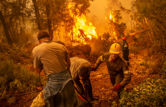 Tűzoltók küzdenek a lángokkal Évia szigetén 2021. augusztus 9-én – Fotó: Angelos Tzortzinis / AFP