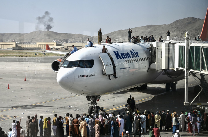 Afgánok kapaszkodnak fel utasszállító repülőgépekre a kabuli reptéren 2021. augusztus 16-án, hogy elmeneküljenek az országból – Fotó: Wakil Kohsar / AFP