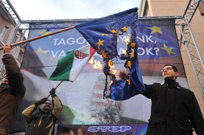 Novák Előd ( ekkor a Jobbik alelnöke) egy uniós zászlót éget pártja „Tagok legyünk vagy szabadok?” elnevezésű tüntetésén Budapesten, az Európai Bizottság Magyarországi Képviselete előtt 2012-ben – Fotó: Koszticsák Szilárd / MTI