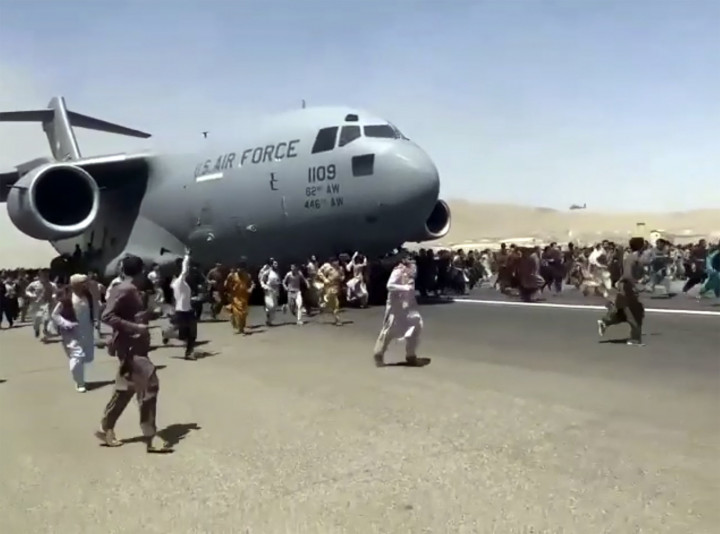 Afgánok próbálnak felkapaszkodni egy C-17-es típusú amerikai katonai szállító repülőgépre a kabuli nemzetközi repülőtér kifutópályáján 2021. augusztus 16-án – Fotó: AP / MTI