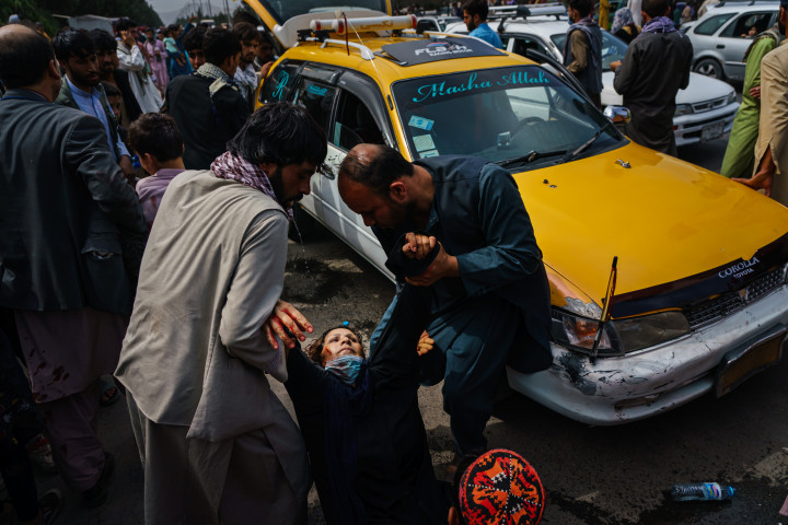 Egy sérült nőnek próbálnak segíteni, miután tálib harcosok rátámadtak a kabuli reptér előtt előtt várakozó tömegre – Fotó: Marcus Yam / Los Angeses Times / Getty Image