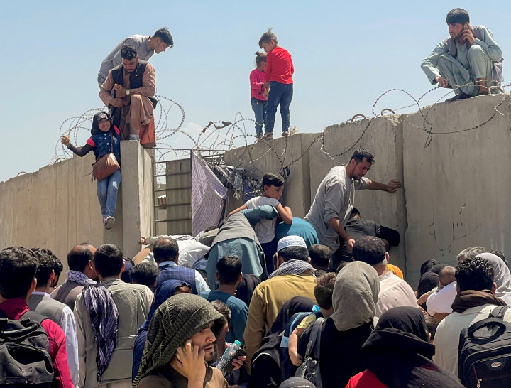 Gyerekeket próbálnak felhúzni a kabuli reptér kerítésén augusztus 24-én. Fotó: REUTERS