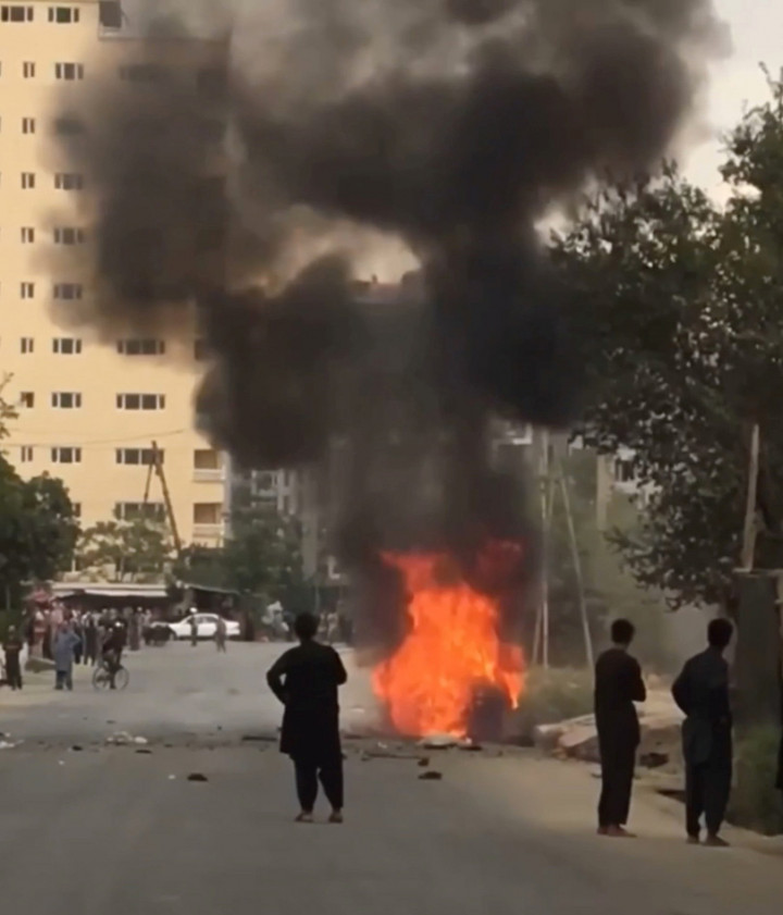 A kabuli nemzetközi reptér felé vezető úton lángoló autó egy videóból kivágott képkockán – Forrás: AAMAJ NEWS AGENCY / REUTERS