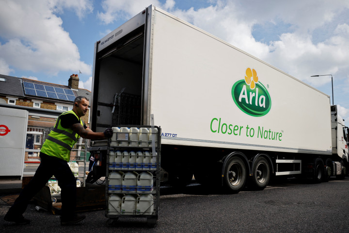 Az Arla Foods sofőrje segít a kiszállított tejtermékek rakodásában egy londoni Tesco áruháznál 2021 augusztusában – Fotó: Tolga Akmen / AFP