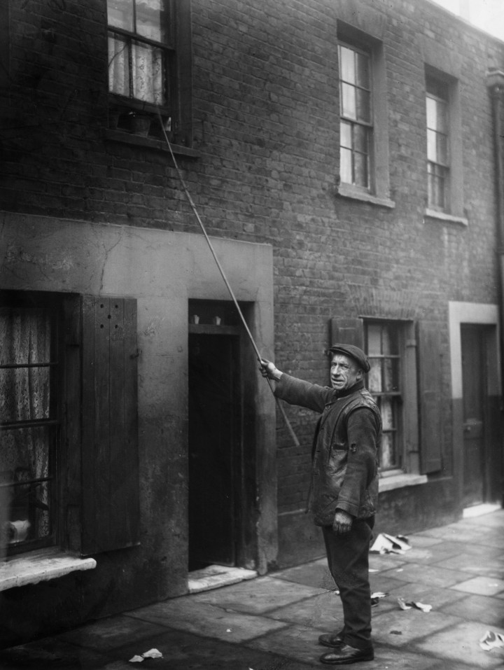 Charles Nelson munka közben 1929. január 24-én. A férfi 25 éven át kopogtatott és ébresztett embereket London keleti részén – Fotó: J. Gaiger / Topical Press Agency / Getty Images