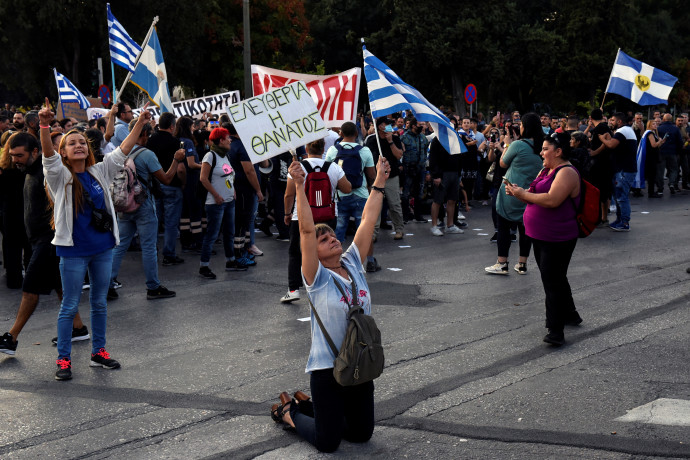 „Szabadság vagy halál” – áll a térdelő tüntető tábláján, a másik kezében görög zászlót lengetve – Fotó: Alexandros Avramidis / Reuters