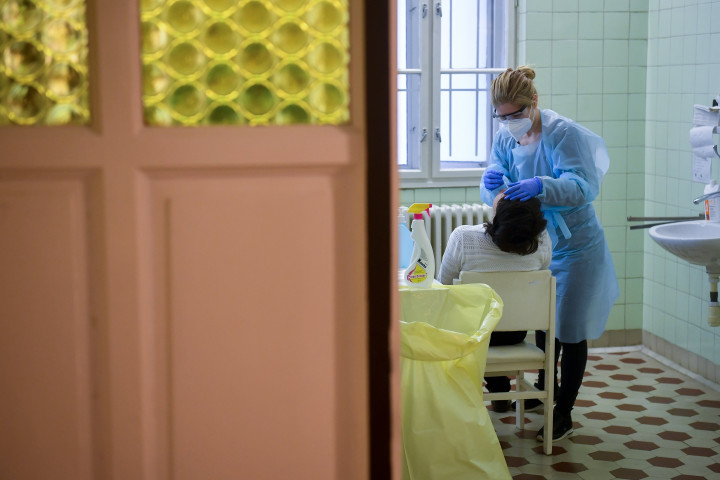 Mintát vesz a Debreceni Alapellátási és Egészségfejlesztési Intézet munkatársa a köznevelésben dolgozók koronavírus-tesztelésén az intézet fogászati ügyeletének épületében 2021. januárjában – Fotó: Czeglédi Zsolt / MTI