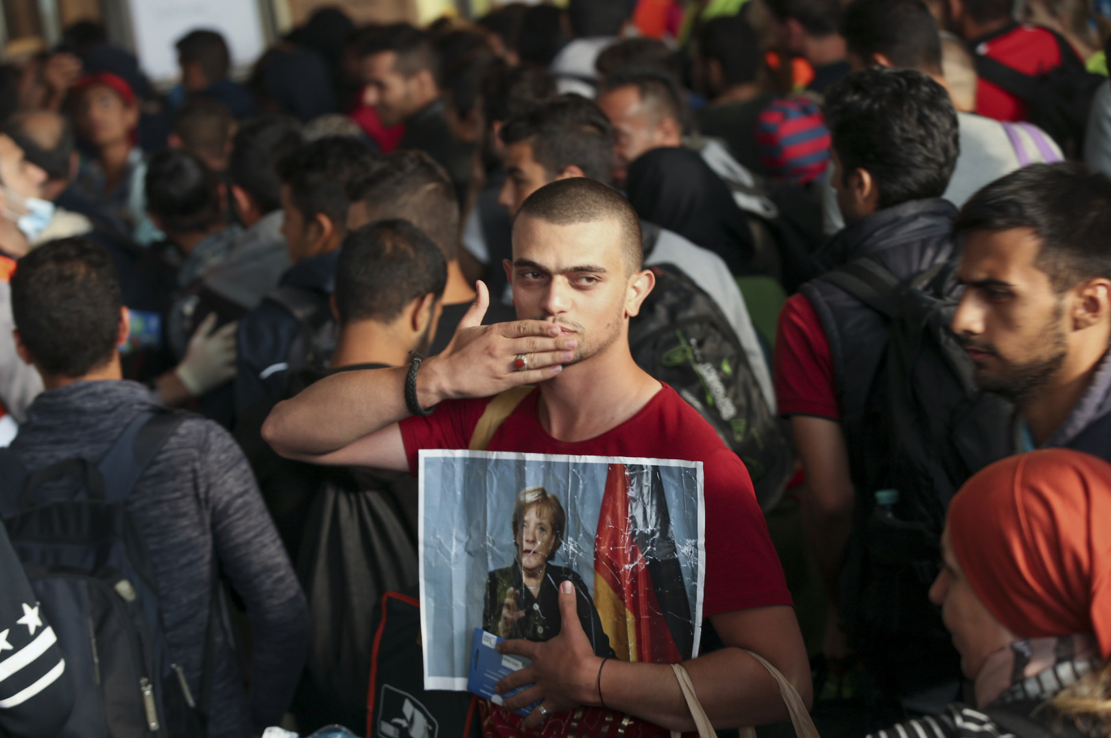 Egy szíriai menekült tartja a kezében Angela Merkel portréját a müncheni főpályaudvaron, miután megérkezett Budapestről 2015. szeptember 5-én – Fotó: Sean Gallup / Getty Images