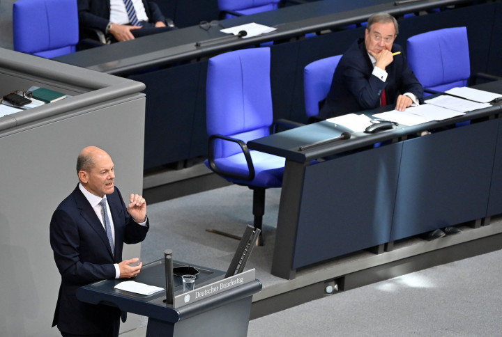 Olaf Scholz a Bundestag pulpitusán mond beszédet, amit Armin Laschet az első sorból figyel – Fotó: John MacDougall / AFP