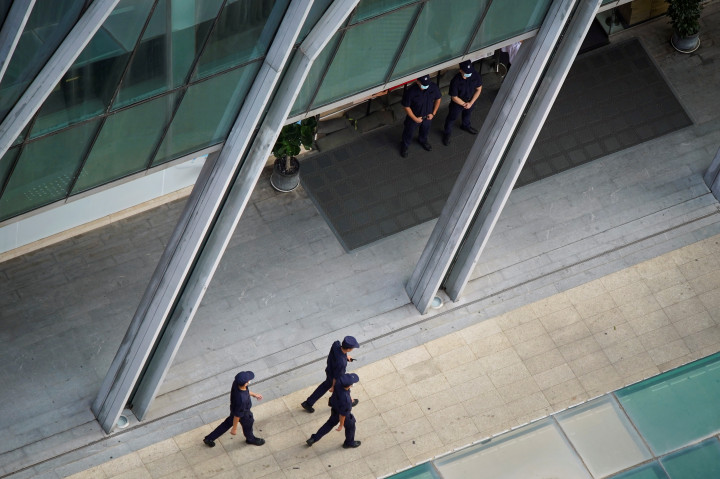 Foto: Biztonsági őrök sétálnak a kínai Evergrande csoport központi épülete előtt, REUTERS/Aly Song 