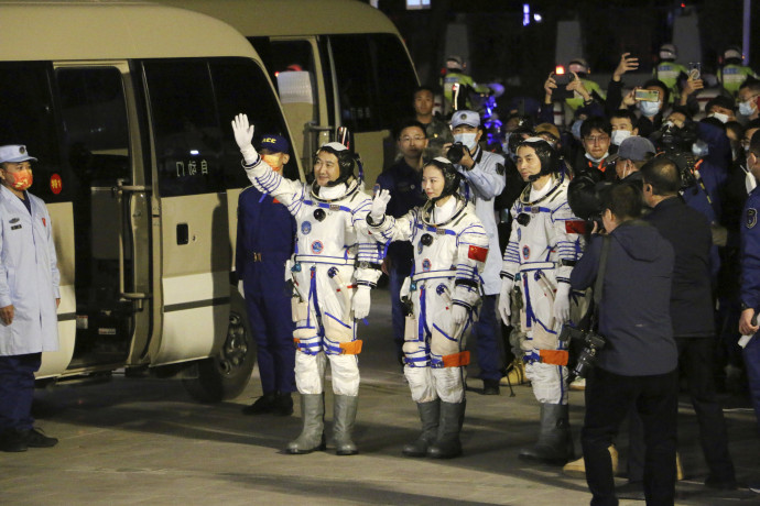 2021. október 15. Csaj Cse-kang, Vang Ja-ping és Je Kuang-fu kínai űrhajósok (b-j) integetnek, mielőtt beszállnak a Sencsou–13 űrhajóba az észak-kínai Kanszu (Gansu) tartományban – Fotó: MTI/AP/Chinatopix