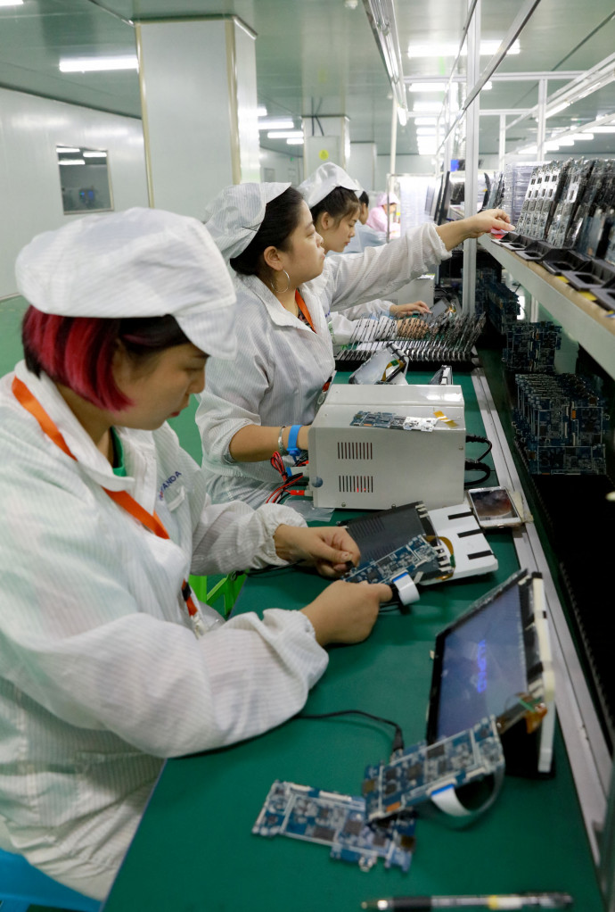 Assembling smart phones in a Sichuan factory, in China – Credit: Zhou Songlin / Imaginechina / AFP