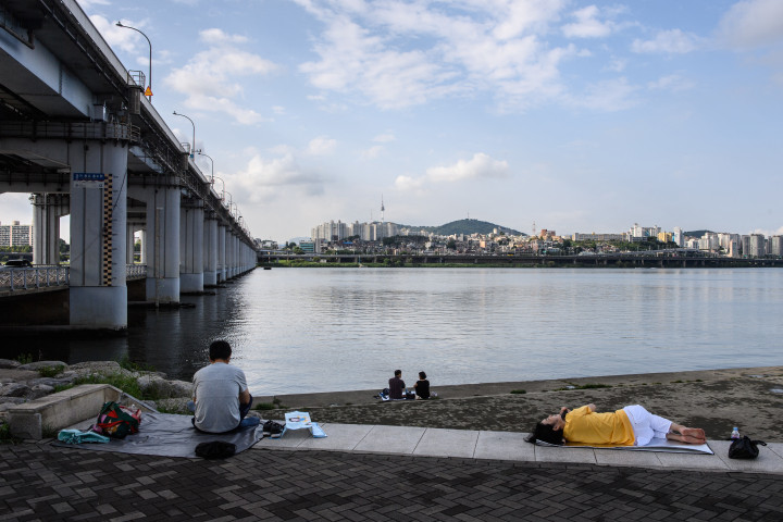 Pihenő szöuliak a Han folyó partján – Fotó: Anthony Wallace / AFP