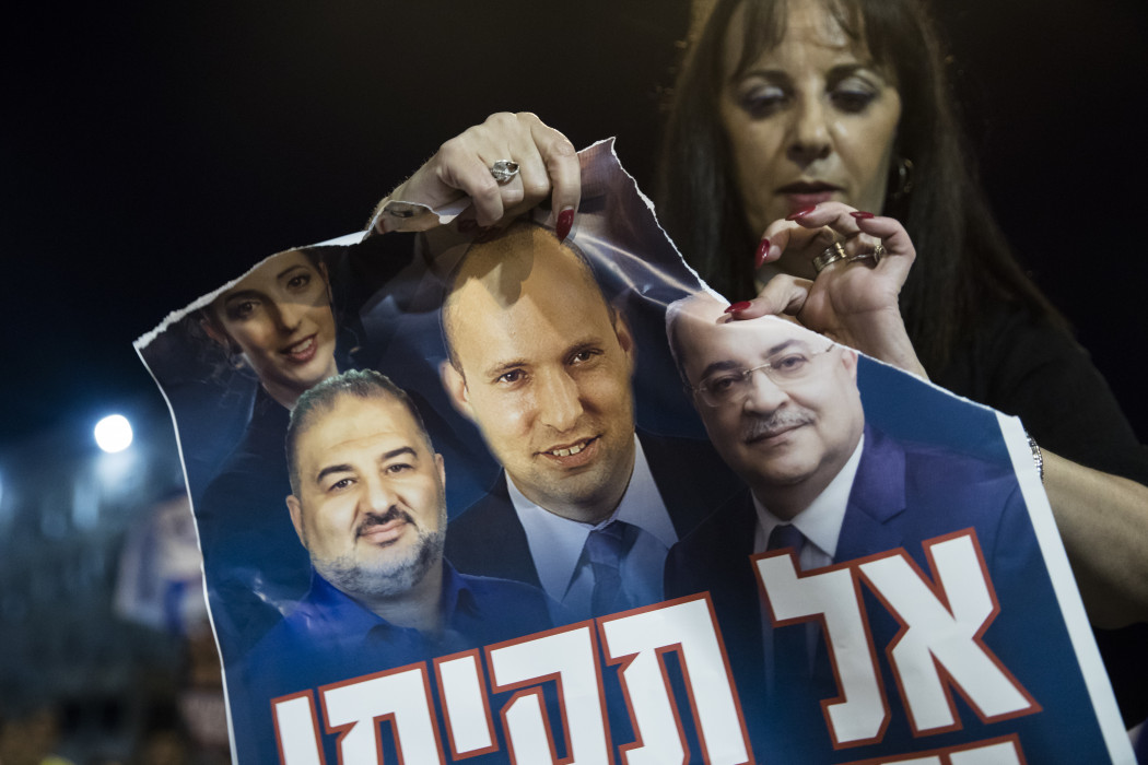Egy résztvevő tépi szét a koalíció plakátját egy Netanjahut támogató tüntetésen 2021 júniusában – Fotó: Amir Levy / Getty Images
