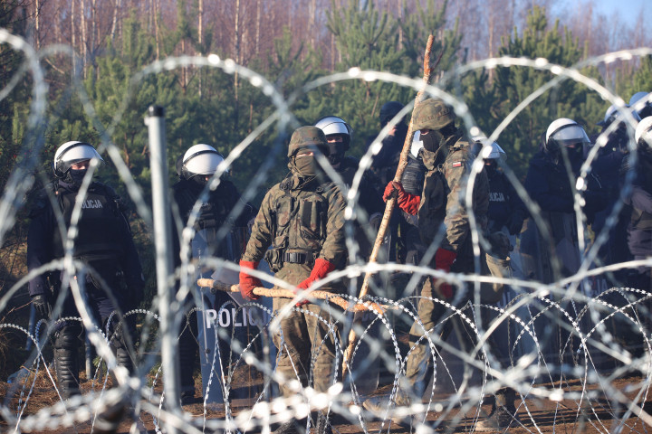 Lengyel katonák a lengyel–belarusz határ drótkerítése mögött – Fotó: Leonid Shcheglov / Belta / AFP