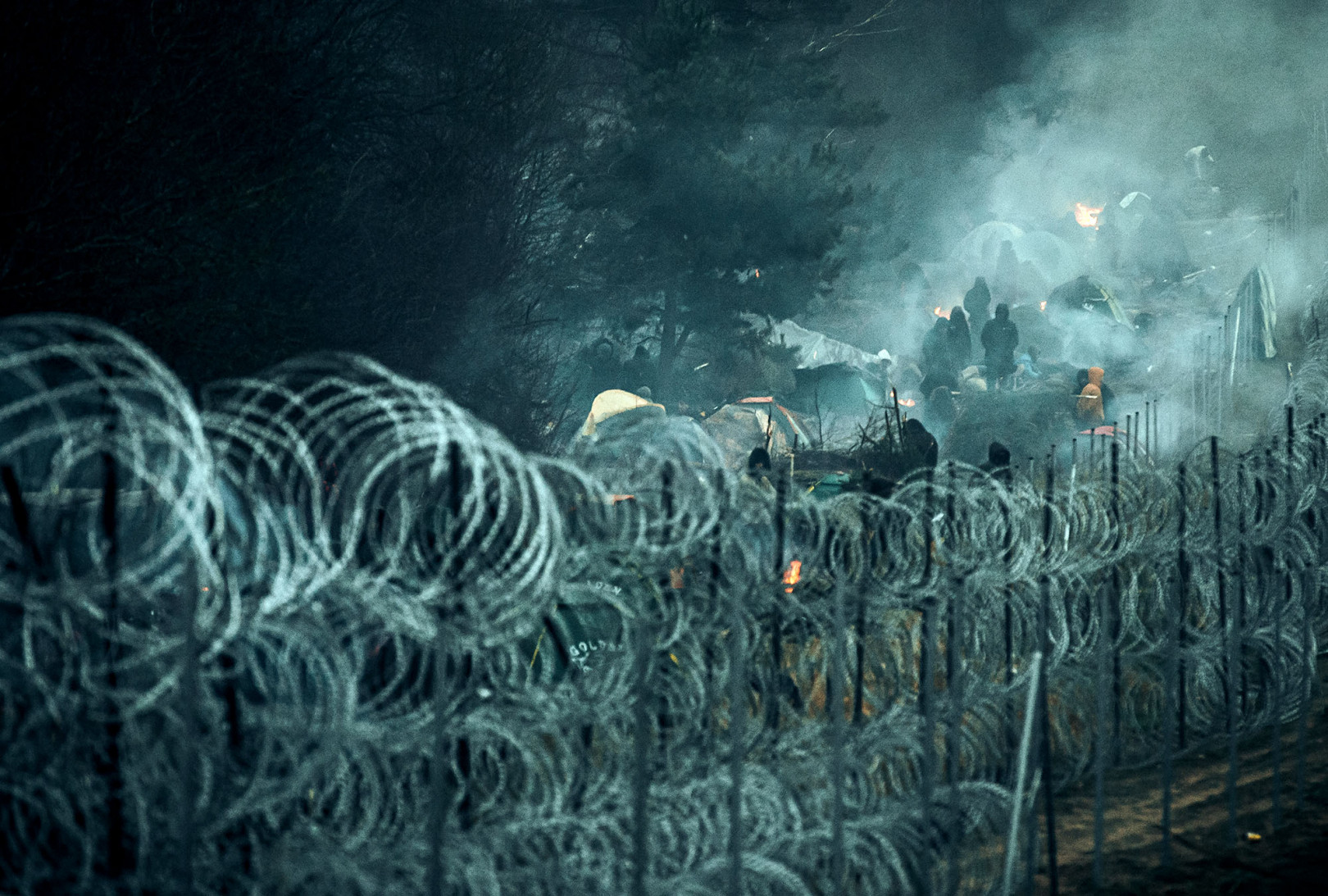 Menekültek a lengyel-belarusz határon felhúzott kerítés mögött a belarusz oldalon 2021. november 9-én – Fotó: Irek Dorozanski / Polish Ministry of National Defence / Getty Images