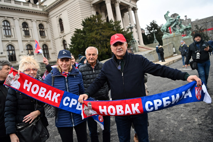 Srdjan Djoković (piros sapkában) egy „Novak Szerbia” feliratú sállal a szerb nemzetgyűlés előtti tüntetésen Belgrádban 2022. január 6-án – Fotó: Andrej Isakovic / AFP