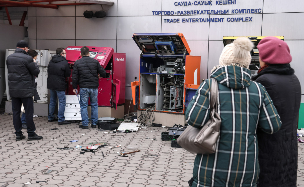 Emberek állnak a megrongált bankautomaták mellett Almatiban – Fotó: Valery Sharifulin / TASS / Getty Images