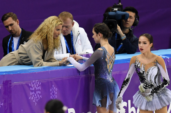 Alina Zagitova és Jevgenyija Medvegyeva készülnek a 2018-as olimpián a női egyéni rövidprogramjuk bemutatására, Tutberidze edzővel – Fotó: Kirill KUDRYAVTSEV / AFP