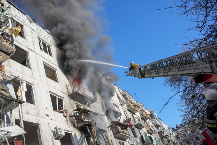 Ukrán tűzoltók megpróbálják eloltani a tüzet, miután légicsapás érte az ukrajnai Harkiv megyei Chuhuiv lakóparkot 2022. február 24-én – Fotó: Wolfgang Schwan / Anadolu Agency / AFP