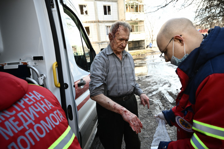 A kelet-ukrajnai Csuhuivban történt bombázások után tűzoltók oltják a lakóépületekben keletkezett tüzet, a mentősök pedig sérültet látnak el – Fotó: Aris Messinis / AFP