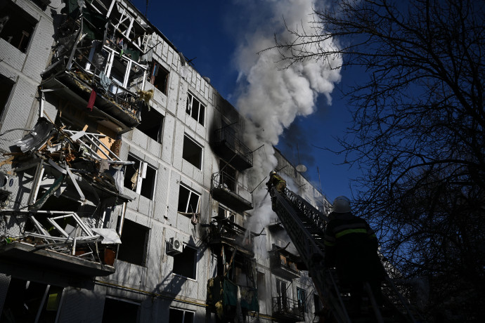 A kelet-ukrajnai Csuhuivban történt bombázások után tűzoltók oltják a lakóépületekben keletkezett tüzet, a mentősök pedig sérültet látnak el – Fotó: Aris Messinis / AFP
