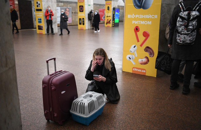 Egy ukrán nő macskahordozóval és bőrönddel a kijevi metróban 2022. február 24-én – Fotó: Daniel LEAL / AFP