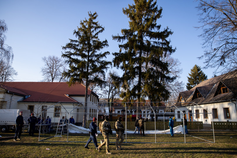 A tarpai művelődési ház előtt fegyveres katonák posztolnak, az udvaron a menekültek fogadására alkalmas sátor épül