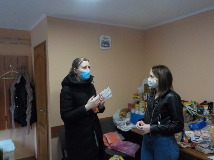 Ina – kék maszkban – ruhákat és tisztálkodási eszközöket hozott – Fotó: Móra Ferenc Sándor/Telex