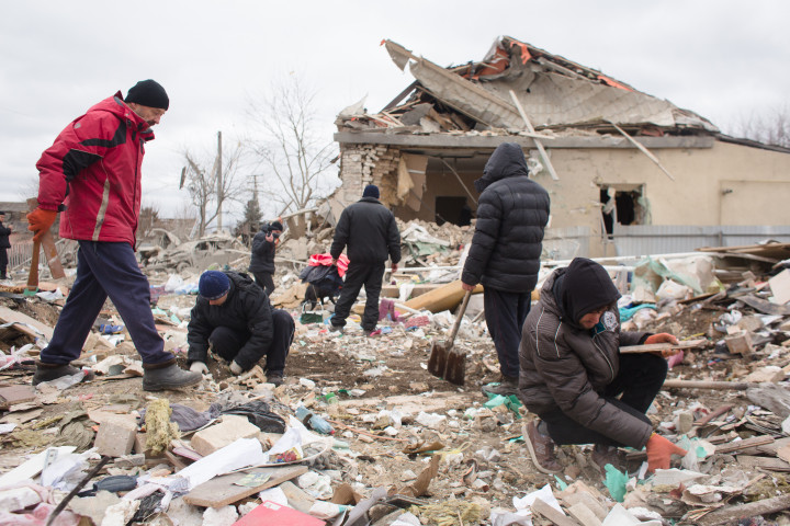 A lakók és szomszédaik takarítják el egy szétbombázott ház romjait a Kijev közeli Markhalivkában 2022. március 5-én – Fotó: Anastasia Vlasova / Getty Images