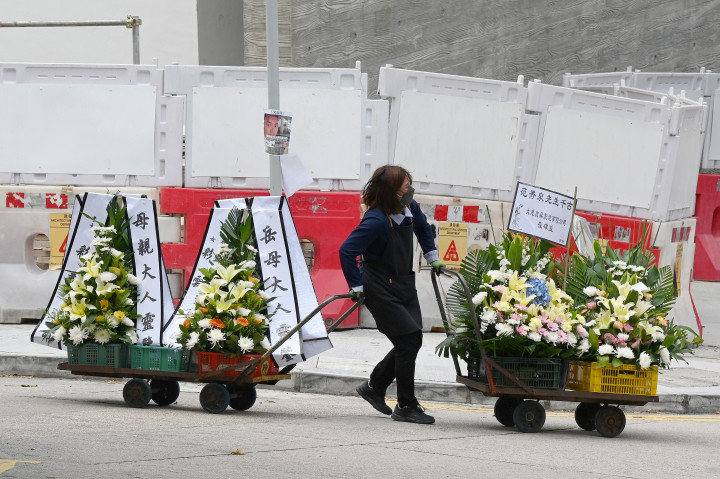 Egy nő koszorúkat húz magával az egyik hongkongi temetőben – Fotó: Peter Parks / AFP