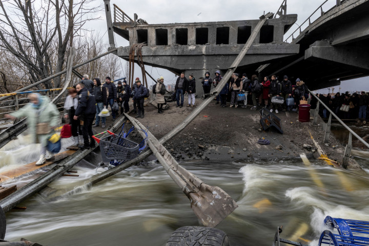 Helyi lakosok menekülnek Iripnyből egy lerombolt hídon keresztül 2022. március 7-én – Fotó: Carlos Barria / Reuters