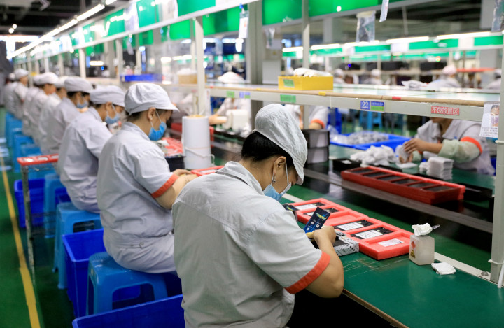Munkások egy elektronikai alkatrészeket gyártó üzemben Szecsuánban – Fotó: Zhou Songlin / Imaginechina / AFP
