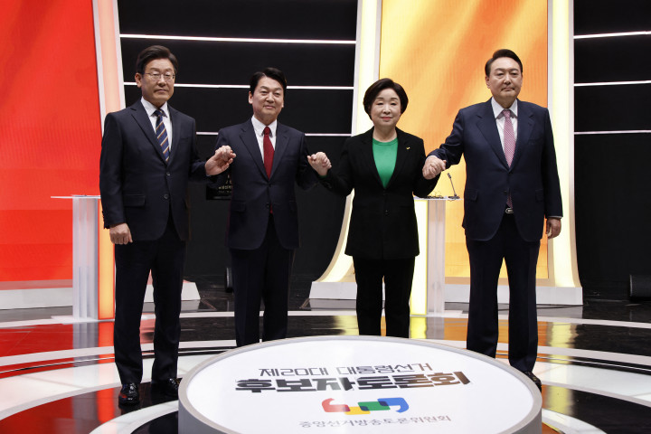 Az elnökjelöltek egy tévévita előtt 2022. február 21-én, a jobb szélen Jun Szogjol, a bal oldalon Li Dzsemjung – Fotó: Heo Ran / Pool / AFP