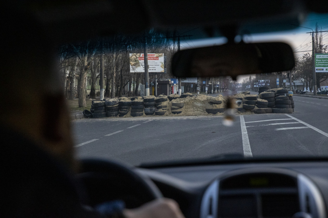Barikádokkal teli főút és a helyszín, ahol vasárnap legalább négy embert megölt egy becsapódó orosz Szmercs rakéta – Fotó: Huszti István / Telex