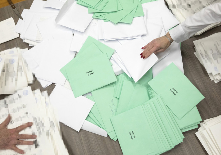 Az átjelentkezéssel szavazók, illetve a külképviseleten szavazók borítékjait keverik a választás estéjén fel nem bontott urnák szavazati közé 2018. április 14-én – Fotó: Mohai Balázs / MTI