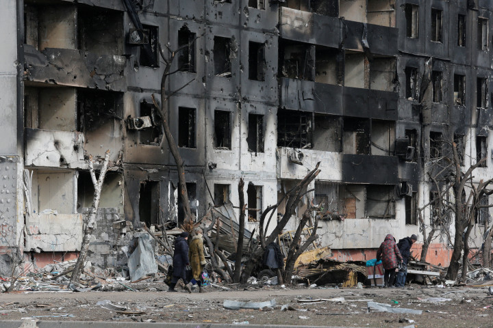 Emberek sétálnak a szétbombázott Mariupolban csütörtökön – Fotó: Alexander Ermochenko / Reuters