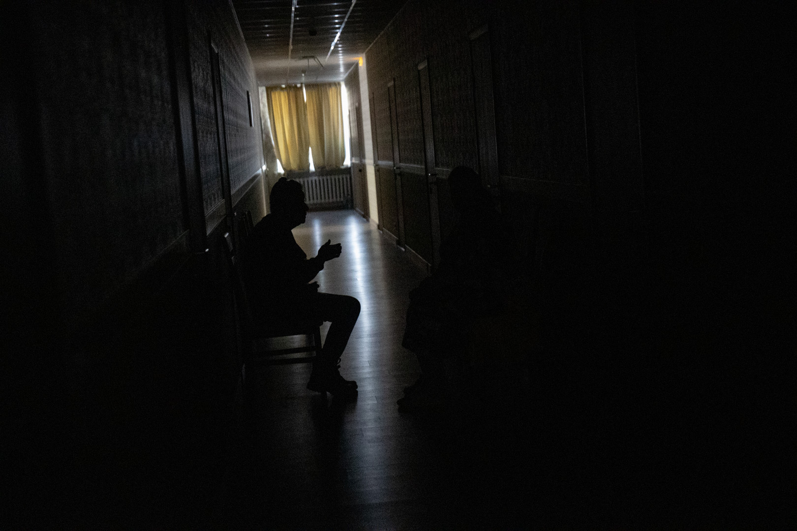 Egy mikolajivi szálló menekült lakói, akik a légiriadó alatt a biztonságosabbnak vélt folyosóra húzódtak be – Fotó: Huszti István / Telex