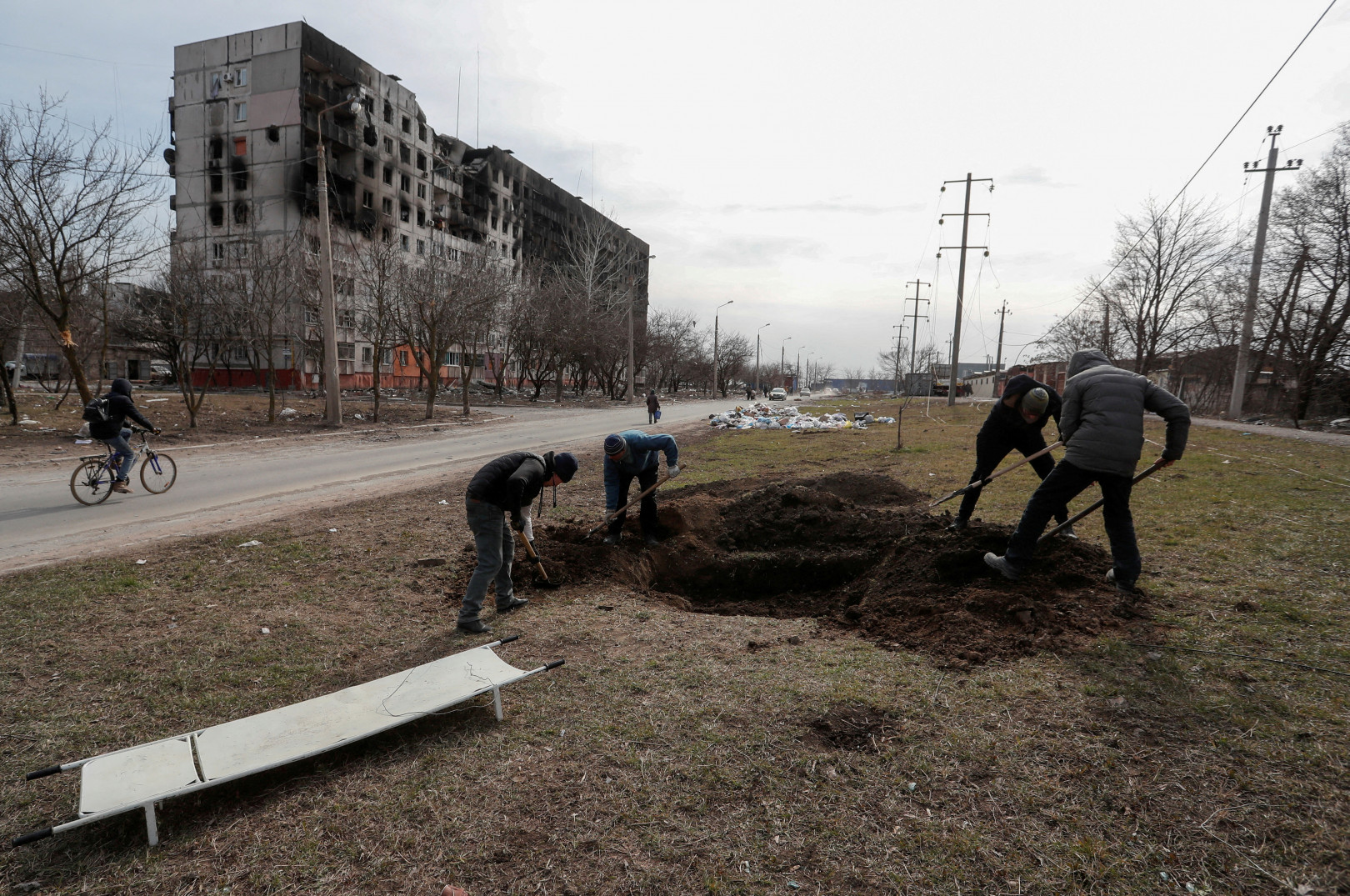 Helyiek sírokat ásnak egy lakótelepen március 20-án – Fotó: Alexander Ermochenko / Reuters