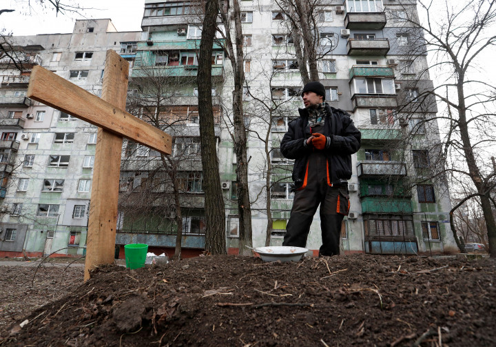 Pavel, egy helyi civil áll az orosz bombázásban meghalt barátja, Igor sírja mellett Mariupolban – Fotó: Alexander Ermochenko / Reuters