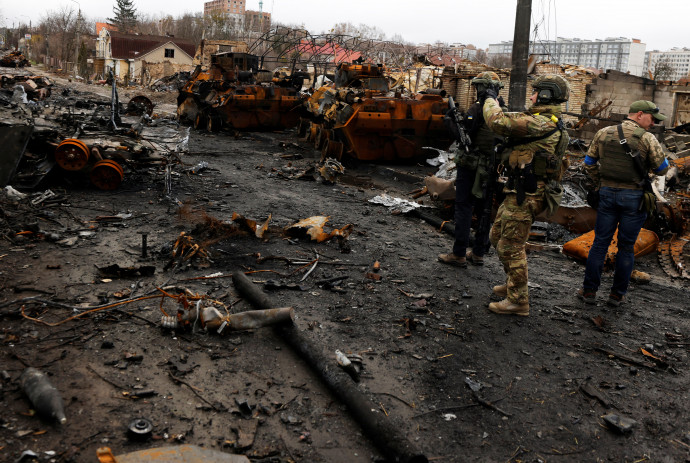 Egy ukrán katona mobiltelefonjával filmez egy megsemmisült orosz tankot és páncélozott járműveket Bucsában 2022. április 2-án – Fotó: Zohra Bensemra / Reuters
