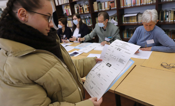 A leghosszabb szavazólapot nézi egy szavazó Fotó: Lehoczky Péter / MTI