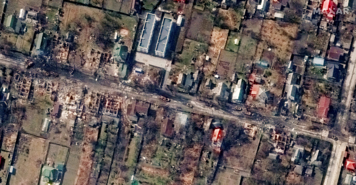 A fenti, március 10-i képen a bucsai Szent András székesegyház környékén lehet felfedezni tömegsírok nyomait, a lenti képen pedig az orosz megszállók által szétrombolt Vokzalna utca házait – Fotó: Maxar Technologies / Handout via Reuters