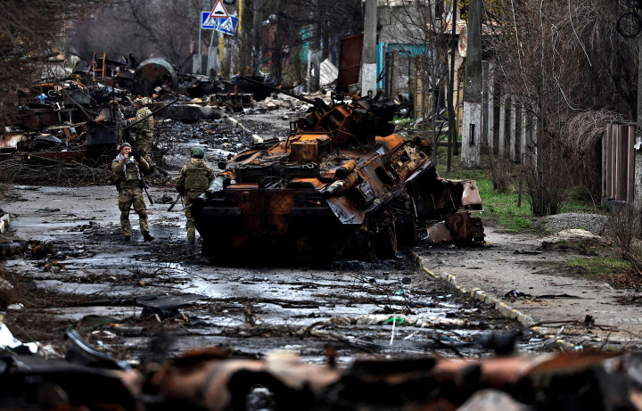 Egy ukrán katona fényképet készít társáról megsemmisült orosz páncélozott járművek között 2022. április 2-án – Fotó: Zohra Bensemra / Reuters